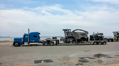 Blue semi with Combine on RGN Trailer